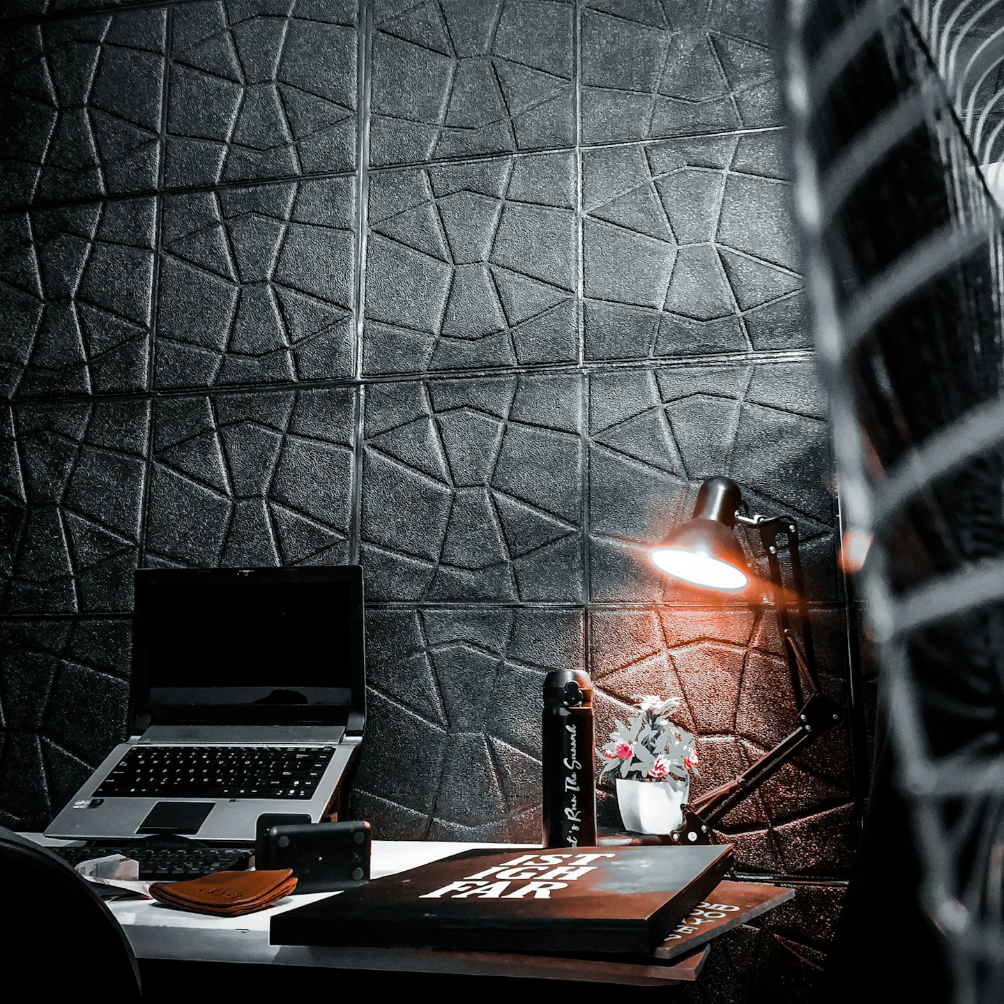 Laptop, water bottle, and book on a desk.